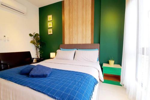a bedroom with a bed with a blue and green wall at Aldridge Residence Cosy Apt @EMIRA Residence in Shah Alam
