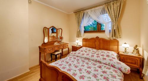 a bedroom with a bed and a dresser and a mirror at Willa Chaber in Zakopane