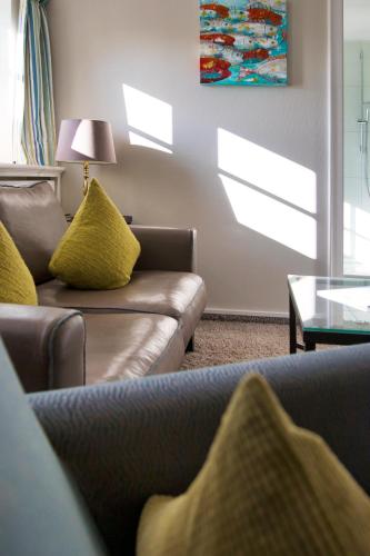 a living room with two couches and a table at Fitschen am Dorfteich in Wenningstedt