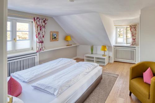 a bedroom with a large white bed and two windows at Fitschen am Dorfteich in Wenningstedt