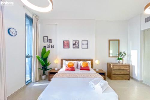 una camera bianca con un grande letto e uno specchio di bnbmehomes - Great Value Modern Studio with Luxury Amenities - 1508 a Dubai