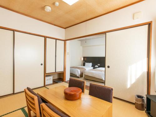a dining room with a table and a bedroom at Wisterian Life Club Nojiriko in Shinano