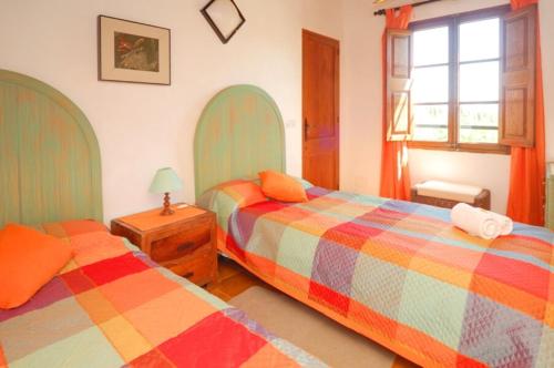 - une chambre avec 2 lits, une table et une fenêtre dans l'établissement Villa Rotger, à Alcúdia
