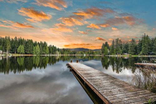 a dock on a lake with a cloudy sky at Moonlight Cottage at Lake Alice in Fall City