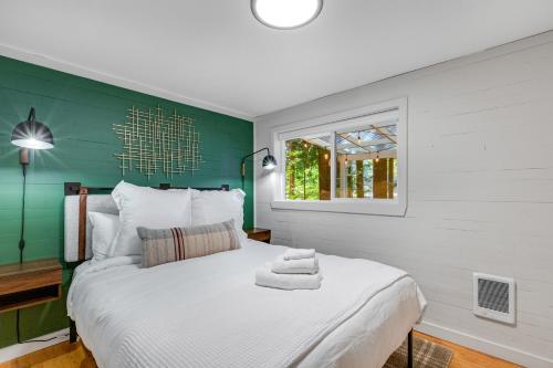 1 dormitorio con cama blanca y pared verde en Moonlight Cottage at Lake Alice, en Fall City