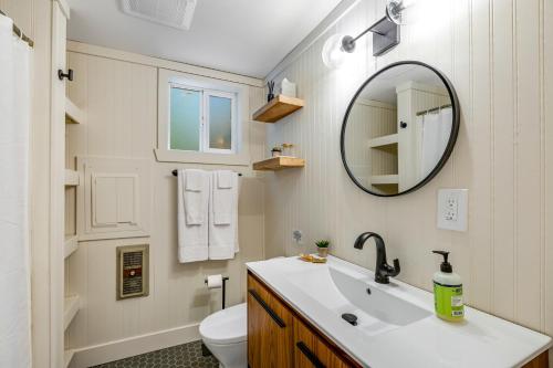 Baño blanco con lavabo y espejo en Moonlight Cottage at Lake Alice, en Fall City