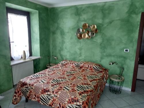 een slaapkamer met een bed en een groene muur bij Ca Dei City in Coazze