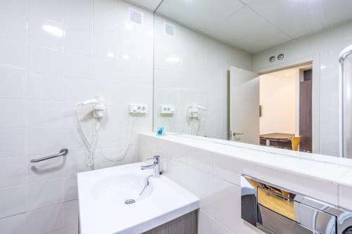 a white bathroom with a sink and a mirror at Residencia Universitaria Resa Erasmo in Madrid