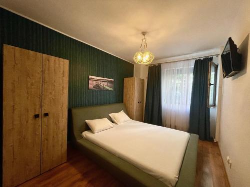 a bedroom with a bed with a green wall at Arcadia Apartament Mamaia Nord in Mamaia Nord