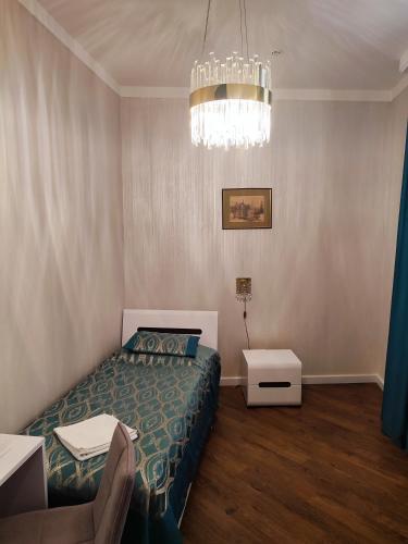 a bedroom with a bed and a chandelier at Nicole in Uzhhorod