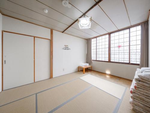 an empty room with white walls and large windows at Super conveniently located The GUEST HOUSE HAKODATE BAY in Hakodate