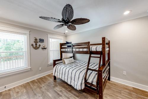 a bedroom with bunk beds and a ceiling fan at Beach Cottage South in Dauphin Island