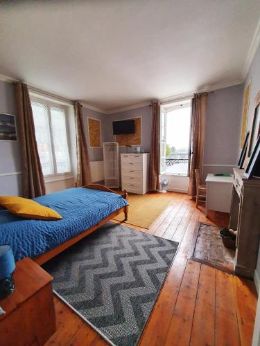 a bedroom with a bed and a desk and windows at Chambres Dhôtes Numéro 1 in Châteaulin