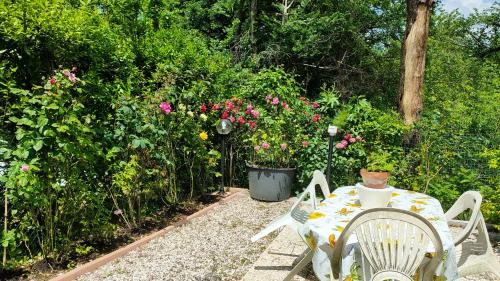 a table and chairs in a garden with flowers at Modern apartment in Borgo San Lorenzo 50 m² with balcony in Borgo San Lorenzo