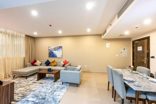 a living room with a couch and a table at Luxe Grand Hotel Apartments in Sharjah
