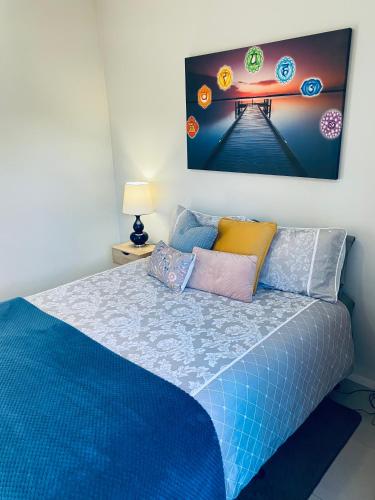 1 dormitorio con 1 cama con una pintura en la pared en Yours and Theirs Pet Friendly Accommodation, en Myrtleford