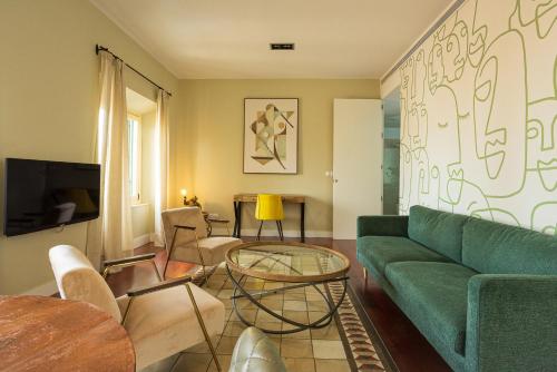 ein Wohnzimmer mit einem grünen Sofa und einem Tisch in der Unterkunft Madeinterranea Apartments in Málaga