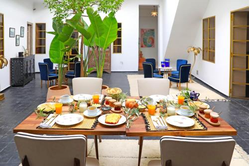 una mesa con comida en una habitación con sillas en Riad la Parenthèse by Sashema en Marrakech