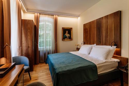 Habitación de hotel con cama y escritorio en Boutique Hotel Dobrna - Terme Dobrna, en Dobrna