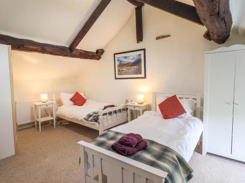 a bedroom with two beds and two tables and two lamps at Blease Garth in Threlkeld