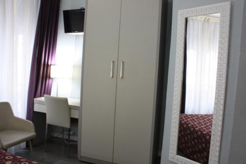 a bedroom with a white cabinet and a mirror at Hotel Excelsior in Paris