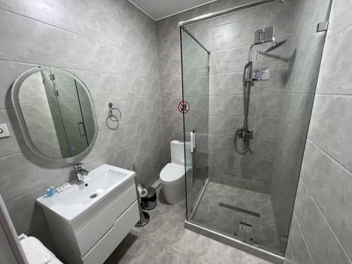 a bathroom with a shower and a toilet and a sink at Hotel Ulug'bek in Bukhara