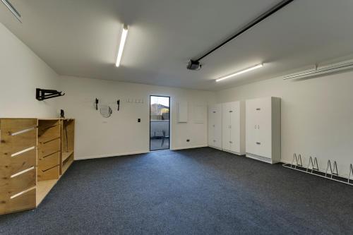 an empty room with white walls and wooden cabinets at Villa Lusso - unwind in luxury and relax in the hot tub in Queenstown