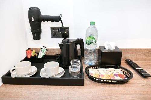 a tray with cups and coffee cups and a coffee maker at The J Hyde Park in London