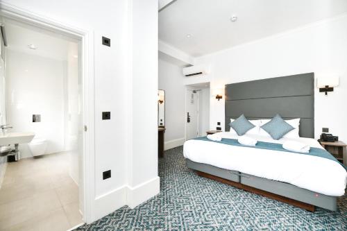 a bedroom with a large bed and a bathroom at The J Hyde Park in London