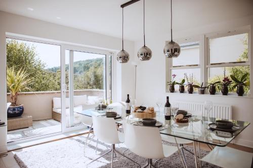 une salle à manger avec une table en verre et des chaises blanches dans l'établissement The Grange Matlock Bath, à Matlock