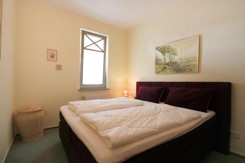 1 cama grande en un dormitorio con ventana en Haus & Villa Strandburg by Rujana, en Binz