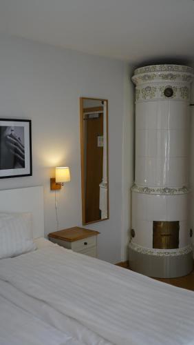 1 dormitorio con cama blanca y espejo en Hotell Hilda, en Kalmar