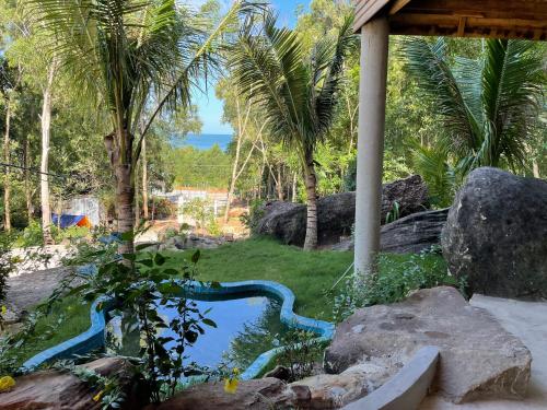 a small pond in a yard with palm trees at COZY HOME PHU QUOC in Phu Quoc