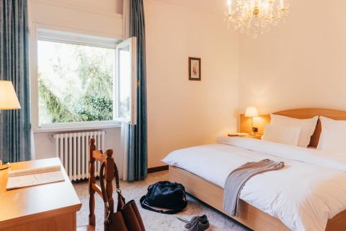 - une chambre avec 2 lits, un bureau et une fenêtre dans l'établissement Hotel Orione - Lake Front Hotel, à Brenzone