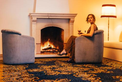 a woman sitting in a chair in front of a fireplace at Hotel Orione - Lake Front Hotel in Brenzone sul Garda