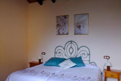 a bedroom with a white bed with blue pillows at Casa Rural El Ñeru in Llanes