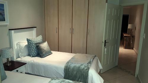 a bedroom with a white bed and a closet at Trevi 11 in Shelly Beach