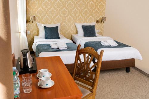 una habitación de hotel con 2 camas y una mesa con sidra de mesa en Aparthotel Globus Kraków, en Cracovia