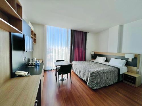 una camera d'albergo con letto, scrivania e tavolo di Sky Roof Hotel a Lefkosa Turk