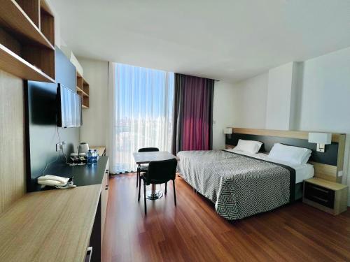 a hotel room with a bed and a desk and a table at Sky Roof Hotel in North Nicosia