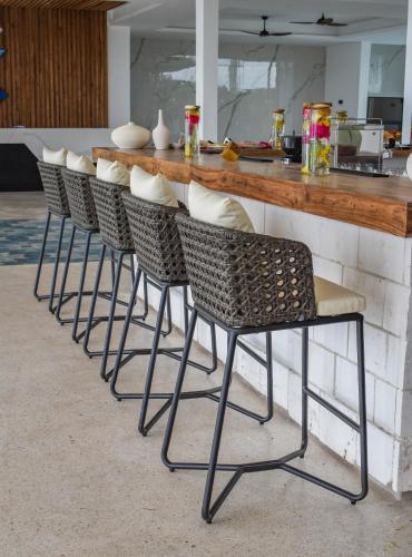 a row of chairs at a counter in a kitchen at Safira Blu Luxury Resort & Villas in Nungwi