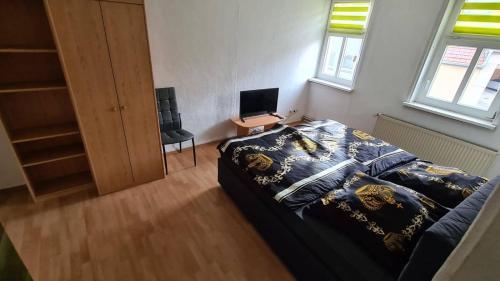 a bedroom with a bed and a desk with a laptop at Zimmer in Nordhausen
