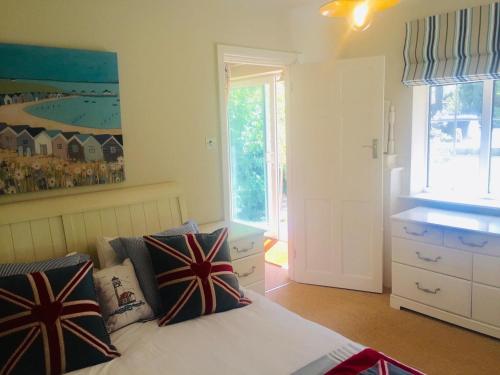 um quarto com uma cama com almofadas em Chadham Pines Cottage em Parkstone