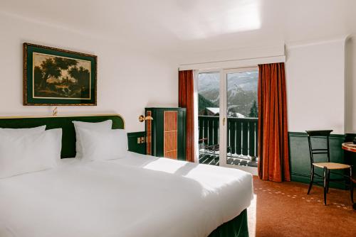 a bedroom with a large white bed and a balcony at Experimental Chalet in Verbier