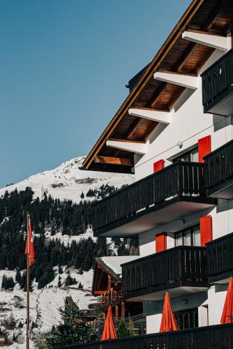 a building with balconies and a snow covered mountain at Experimental Chalet in Verbier