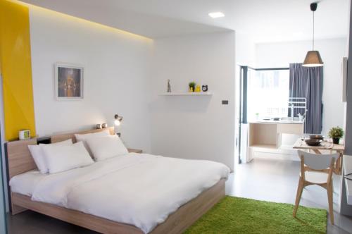 a bedroom with a bed and a desk with a chair at A23 residence in Ban Na Song