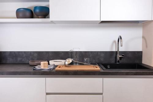 a kitchen with white cabinets and a sink and a counter at Residenza SubitoSanto - Appartamento 5A "Obizzi" in Padova