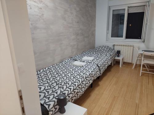 una camera con un letto con una coperta bianca e nera di City Passage Apartments- Rooms a Novi Sad