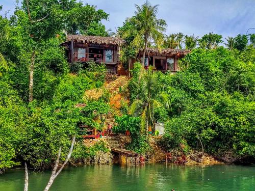 a house on the side of a hill next to a river at The River Hideaway in General Luna