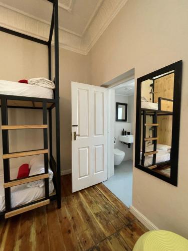 a room with bunk beds and a bathroom with a mirror at Villa Viva Cape Town in Cape Town